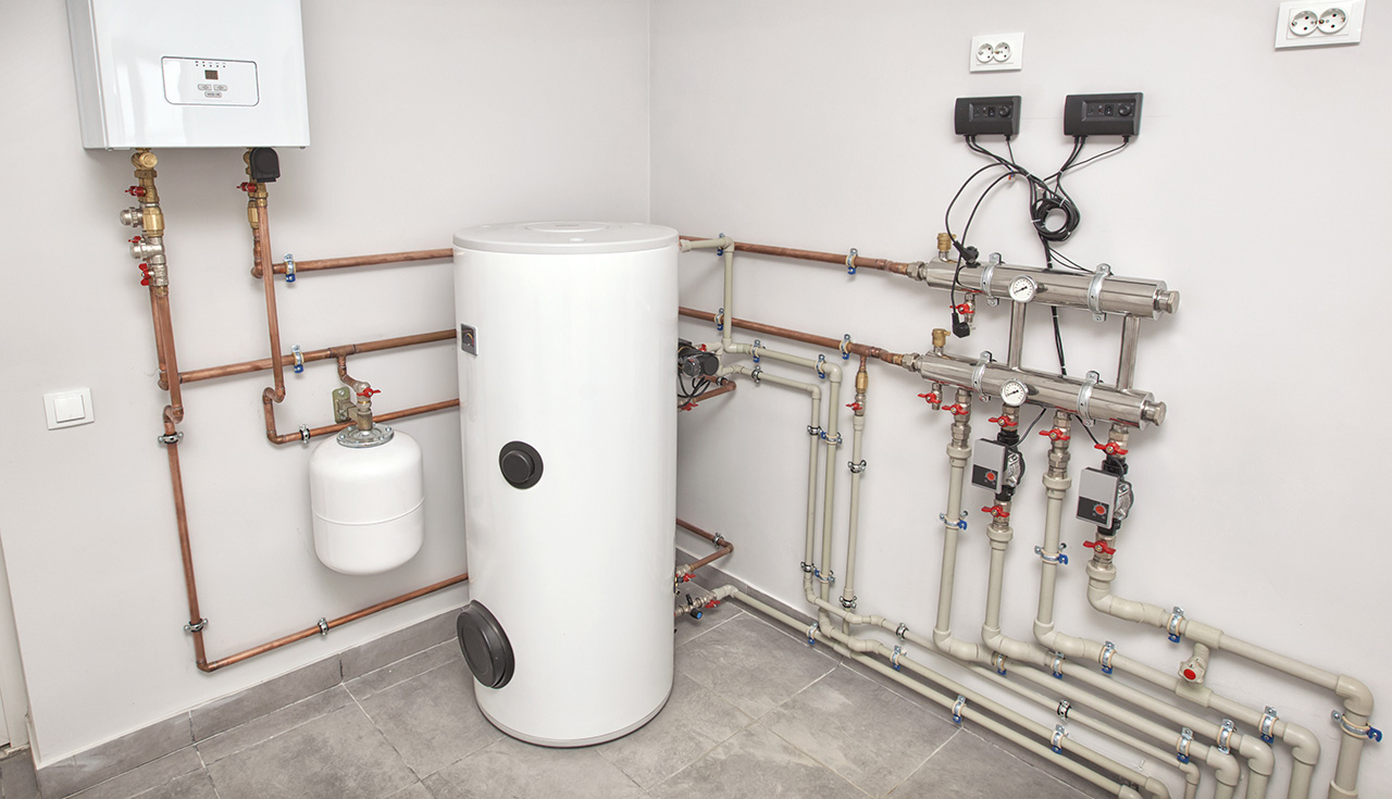 A neatly organized indoor plumbing setup with copper pipes, valves, and a white cylindrical tank, mounted on tiled walls.